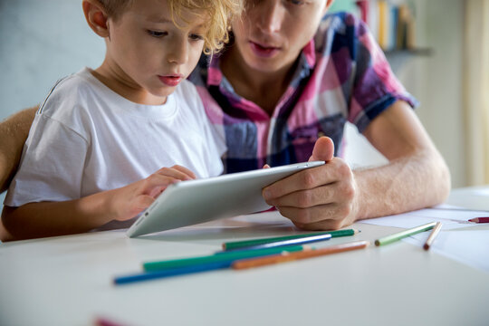 Father and son using tablet PC at desk
