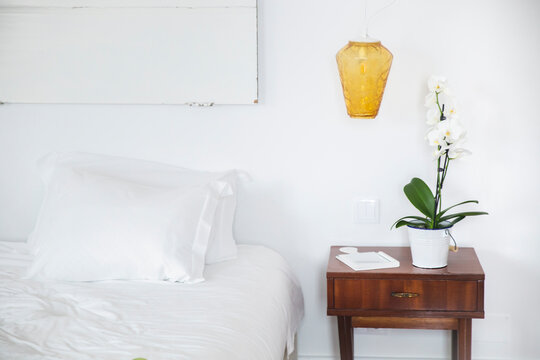 Pendant light over side table by bed in hotel