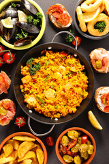 Assorted Spanish food set Paella seafood platters,  mussels,  fried onion rings, patatas bravas,...
