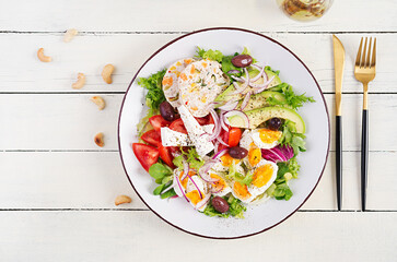 Chicken meatloaf and fresh vegetable salad of tomato, avocado, eggs, lettuce and feta cheese. Ketogenic, keto diet. Top view, overhead