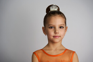 Cute little girl in orange dress posing over white background