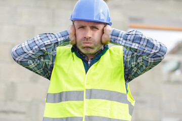 construction suffering from noise pollution on building site - obrazy, fototapety, plakaty