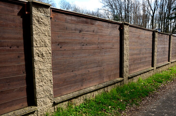 wooden fence made of natural planks. the columns are made of roughly plastered white columns. full...