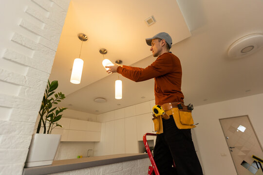 Electrician in uniform repairing ceiling lamp indoors Generative AI