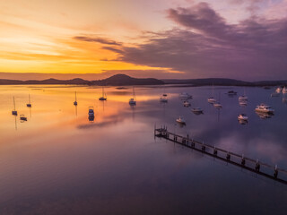 Aerial sunrise waterscape with boats and high cloud