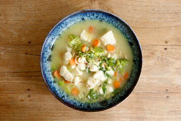 Fresh fish soup with vegetables on wood table with copy space High angle view