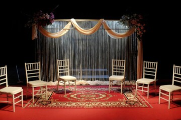 Stage performance with classic decor, curtains, red carpet and props seats.