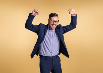 Successful young businessman with eyes closed and arms raised screaming cheerfully isolated against...