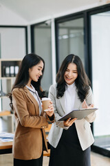 Kind leader executive manager share and discuss business solutions plan ideas on tablet with Asian female marketing manager in office.