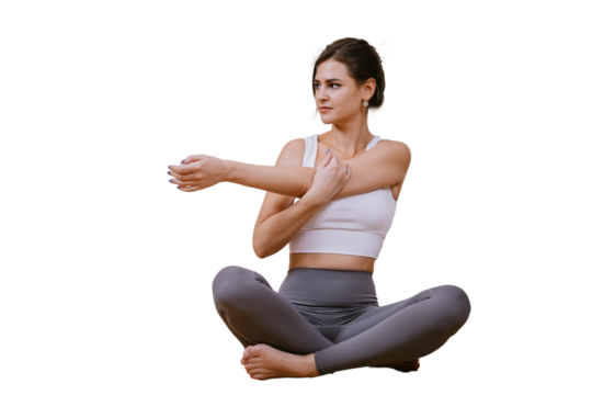 Beautiful American young brunette woman in sportswear sitting on floor stretching practicing yoga against transparent background. Focused hispanic female at exercise at fitness club. Healthy lifestyle