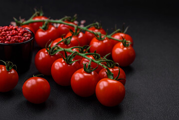 Delicious fresh cherry tomatoes on a twig with spices and herbs