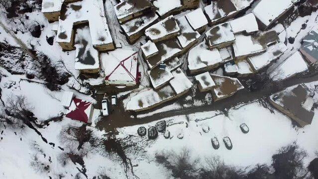 Hizan, Bitlis, Turkey - February 2020: Drone shot of remote village in Eastern Turkey Anatolia with stone houses, snowy landscape