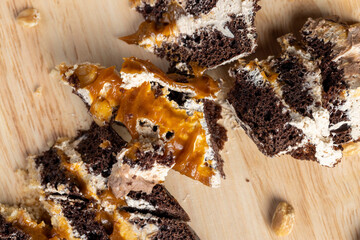 a piece of chocolate cake with caramel and peanuts