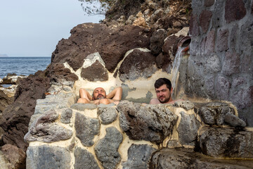 Man and guy bathing in a thermal spring with hot, healthy, mineral waters (Peloponnese, Greece).