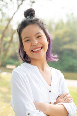 Happy teen girl 11-15 year old. Portrait of beautiful woman smiling with perfect smile and white teeth and looking away at park during sunset. Smile face asian lady girl wear casual cloth.