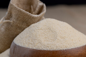 Semolina poured into a round wooden bowl ready for cooking