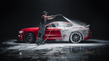 Automotive Detailer Washing Away Smart Soap and Foam with a Water High Pressure Washer. Close Up of...
