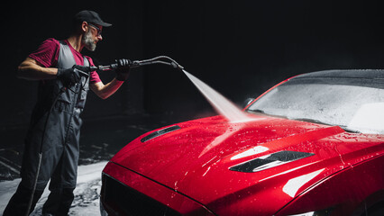 Advertising Style Photo of a Professional Car Wash Specialist Using a High Pressure Washer to Clean...