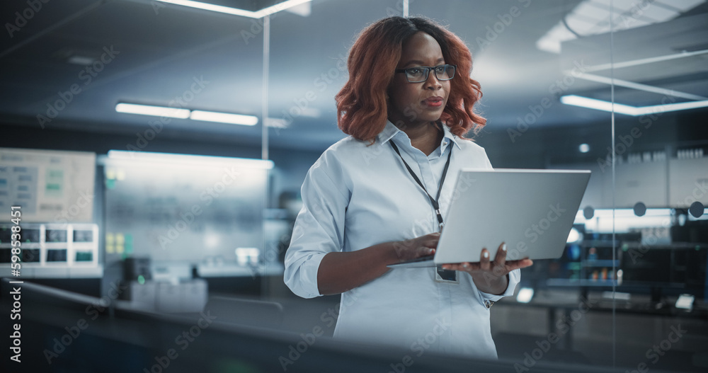 Aufkleber Technological Software Engineering Department Manager Standing and Using a Laptop Computer. Black Female Looking in the Distance and Thinking while Working in the Office