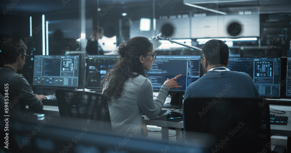 Leinwandbilder Diverse Young Colleagues Working on Computers in a Research Laboratory. Female Asking Advice from a Male Software Developer Colleague About a Solution for Their Collaborative Industrial Tech Project