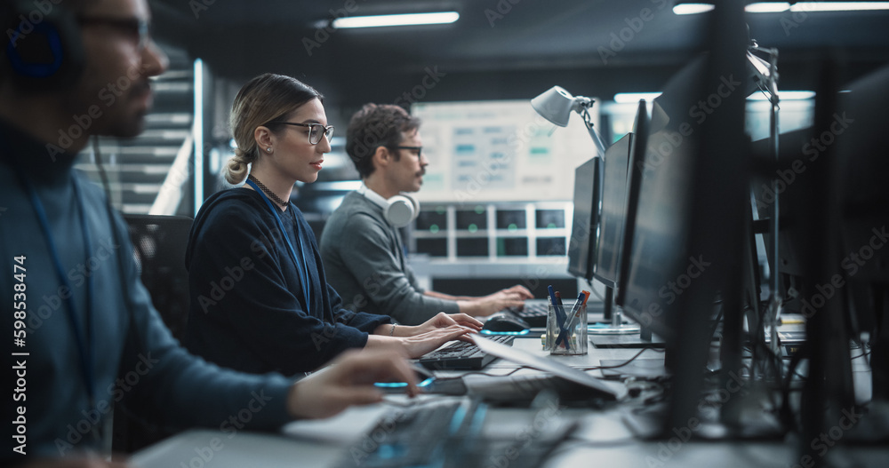 Poster focused young multiethnic female software developer working on computer together with two creative m