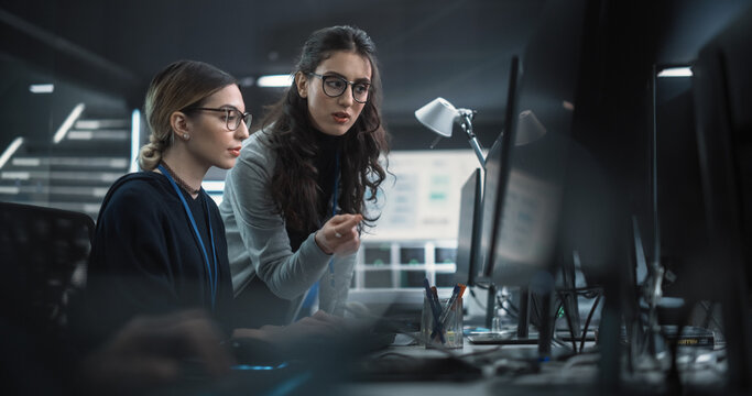 Young Multiethnic Female Software Developer Working on Computer, Discussing Project with Team Leader. Data Protection Center with Servers, Storage Hardware and Cyber Security Research