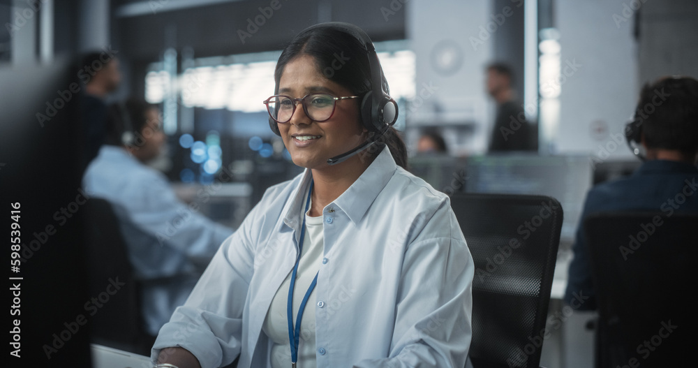 Fototapete Help Desk Specialist Answering a Call, Providing Technical Support to Client Experiencing Computer Hardware and Software Issues. Indian Female Using a Headset to Have a Conversation with a Tech Team