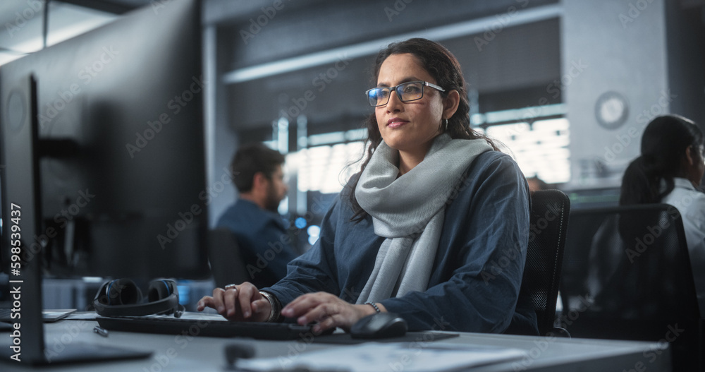 Fototapete Portrait of a Thoughtful South Asian Engineer Working on Computer in a Technological Corporate Office. Young Woman Writing Software Code for an Innovative Internet and Software as a Service Project