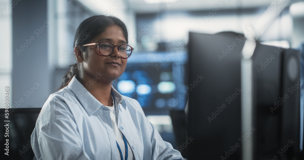 Poster portrait of a smart focused south asian engineer working on computer in a technological corporate of