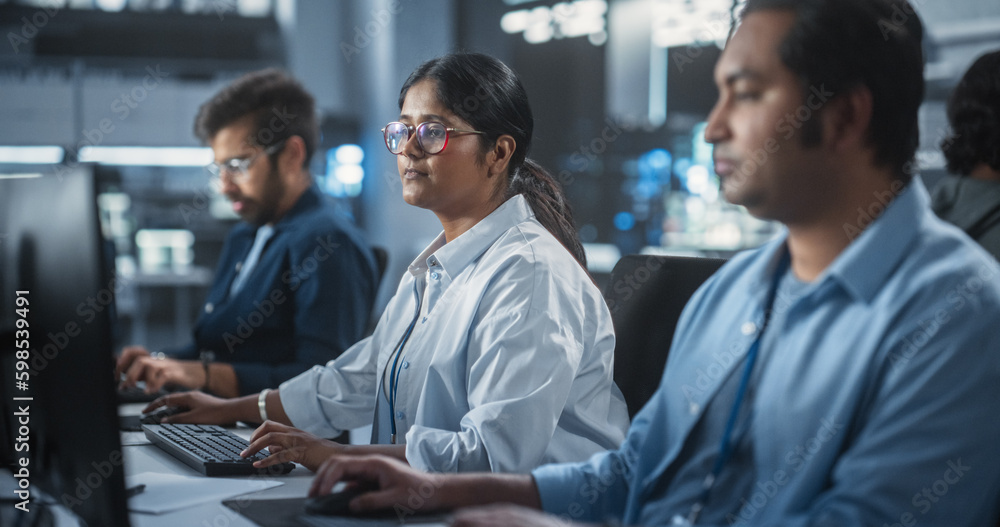Fototapete Young Team of Female and Male South Asian Specialists Working on Computers and Having a Conversation at a Workplace. Two Programmers Discussing a Solution for Their New Software Upgrades