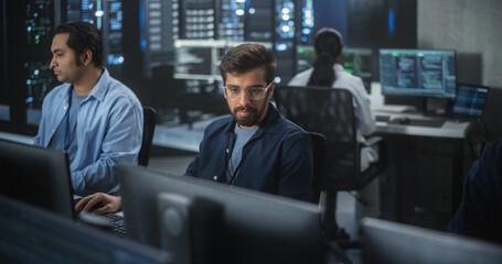 Young Team of South Asian Specialists Working on Computers and Having a Conversation at a Workplace. Two Male Software Developers Discussing a Solution for Their Artificial Intelligence Project