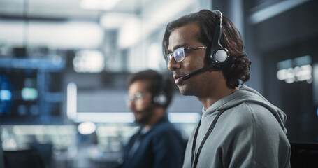 Help Desk Specialist Answering a Call, Providing Technical Support to Client Experiencing Computer Hardware and Software Issues. Indian Male Using a Headset to Have a Conversation with a Tech Team