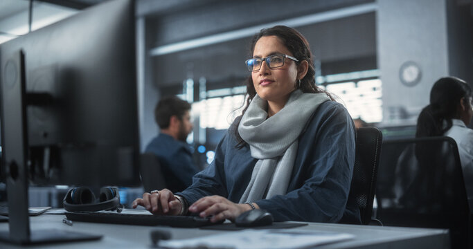 Portrait Of A Thoughtful South Asian Engineer Working On Computer In A Technological Corporate Office. Young Woman Writing Software Code For An Innovative Internet And Software As A Service Project