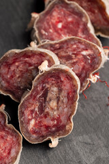 Unpeeled sliced pork salami with spices