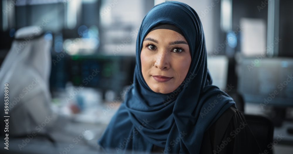 Aufkleber Portrait of a Middle Eastern Female Using Desktop Computer, Looking at Camera and Smiling. Empowered Muslim Information Technology Specialist, Software Engineer, Developer or Data Scientist
