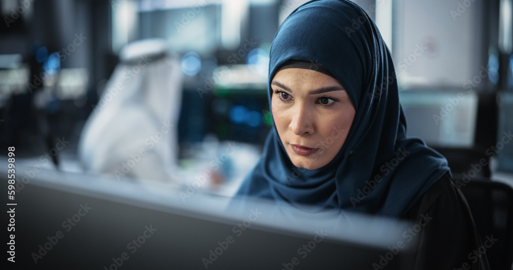 Aufkleber Portrait of a Thoughtful Middle Eastern Engineer Working on Computer in a Technological Corporate Office. Young Woman Writing Software Code for an Innovative Internet and Software as a Service Project