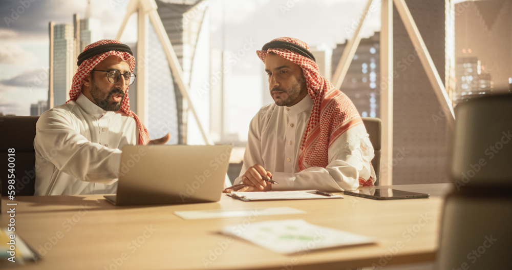 Aufkleber two young muslim financial advisers use laptop computer to discuss a stock market strategy in a mode