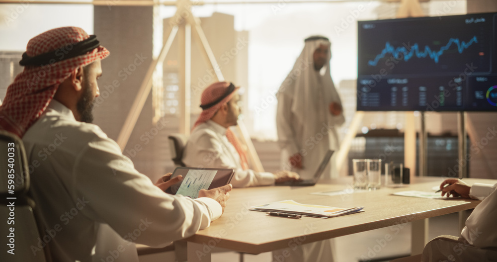 Poster Muslim Businessman Using a Tablet Computer at a Meeting with Corporate Partners. Manager Getting Familiar with Financial Annual Report while Listening to the Presentation in Conference Room