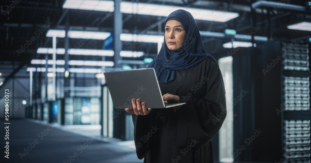 Aufkleber Muslim Female Data Center IT Engineer Standing in a Room with Server Racks. Cloud Computing Architect Uses Laptop Computer for Servicing the System in Cyber Security and Data Protection Facility