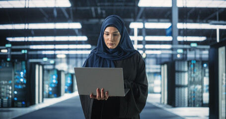 Muslim Female Data Center IT Engineer Standing in a Room with Server Racks. Cloud Computing...