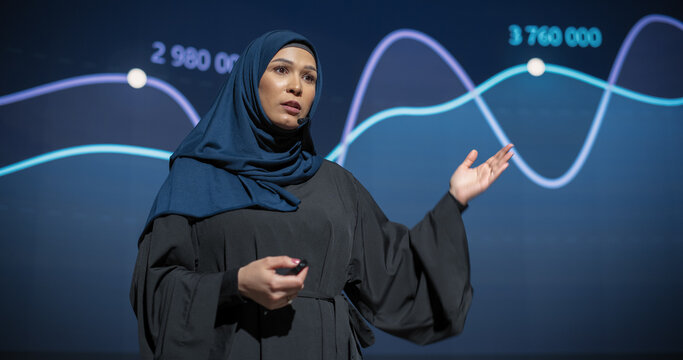 Business Expo Stage: Famous Inspirational Speaker From Gulf Region Talking about Technology, Science, Success, Productivity. Tech Industry Businesswoman in Traditional Arab Hijab Giving a Presentation