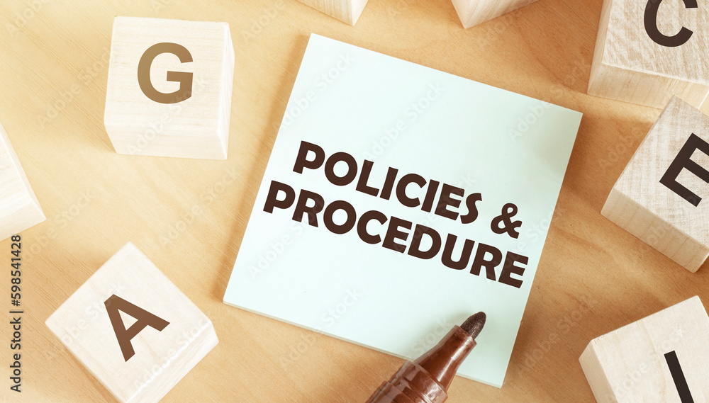 Poster sticker with text policies and procedure in the middle of wooden cubes with letters