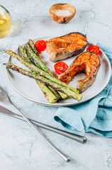 Grilled salmon with asparagus on gray marble background. Mediterranean diet concept.