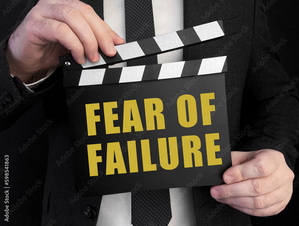 Poster a businessman holds up a ?lapperboard with text fear of failure
