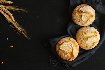 Three buns on a black board with a dark cloth, top view. Selective focus, natural light with copy space