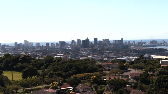 Wide drone aerial shot from the Berea suburb towards Durban city skyline and port with the sea on the horizon.