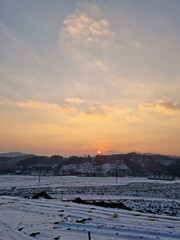 Rural winter landscape at sunset