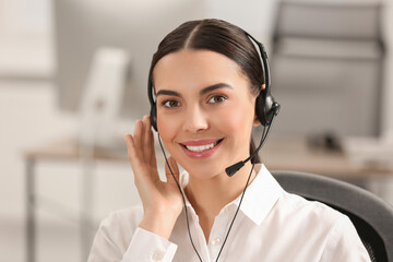 Hotline operator with headset working in office