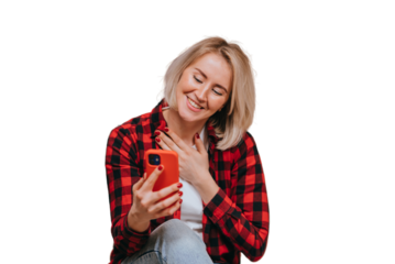 Grateful young blonde American woman in plaid shirt makes video call smiles wide presses on chest by hand feels gratitude, sits at home against transparent background with view on sunset. Relationship