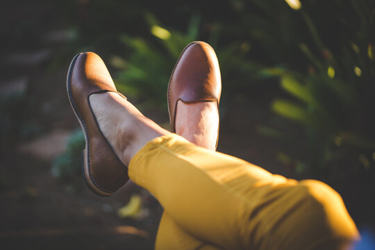 Close up image of a pretty woman with muscular legs wearing handmade leather shoes.